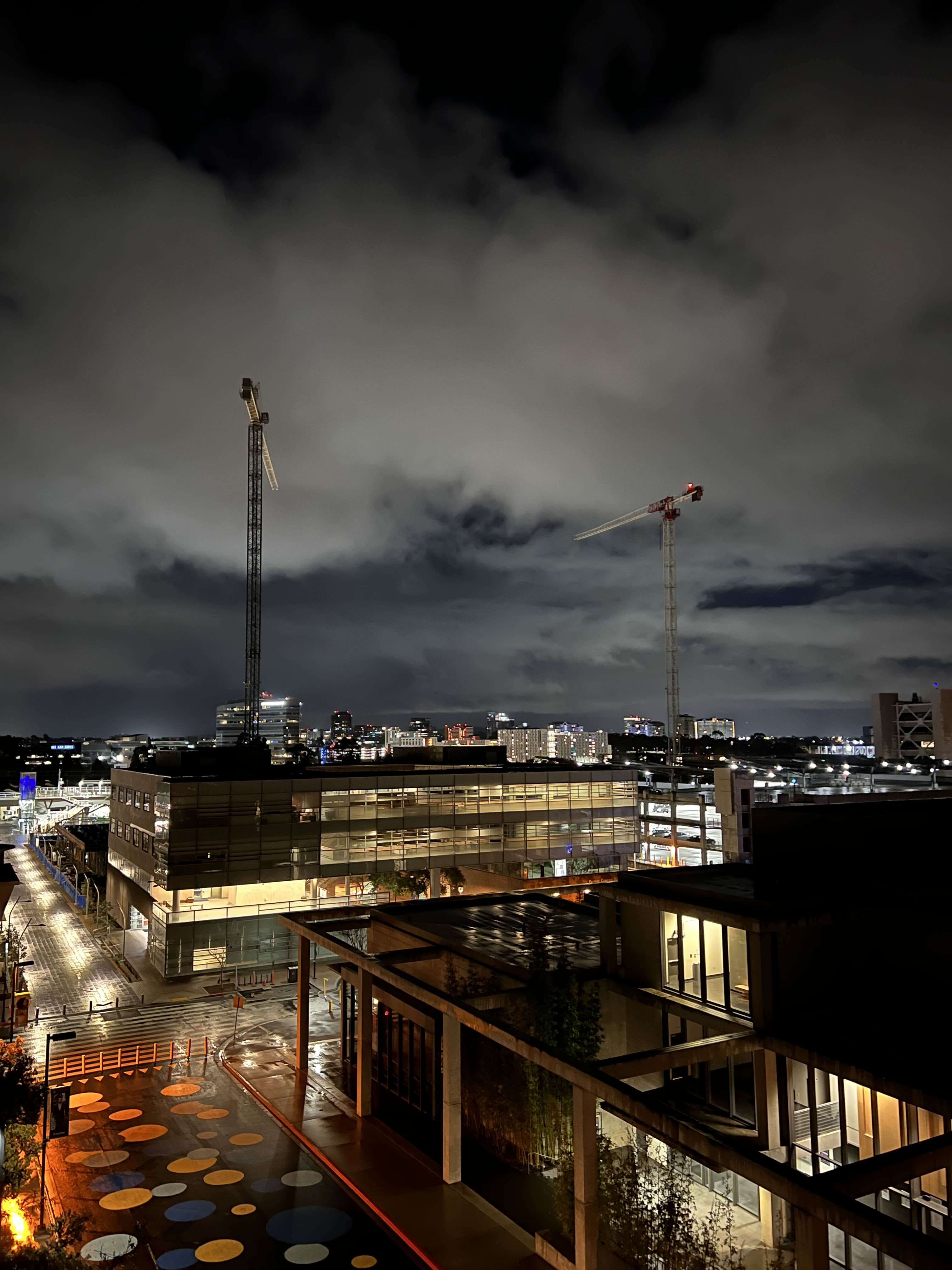 Construction cranes among clouds